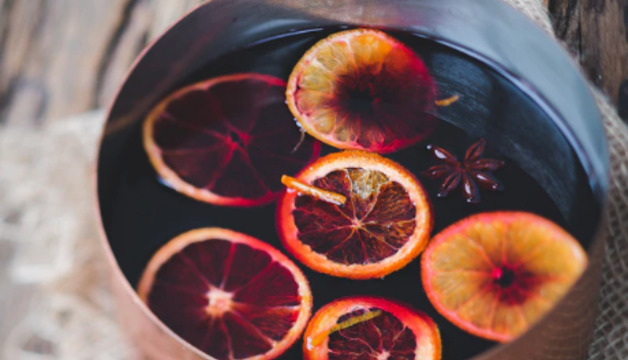 Glühwein mit Orangen im Kochtopf